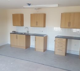2 separate long kitchen cabinets with three light brown cupboards above.