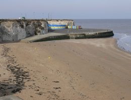 A sandy beach with cliffs in the distance