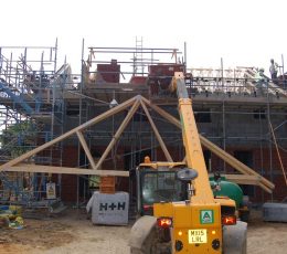 Roof frame being lifted onto house during construction