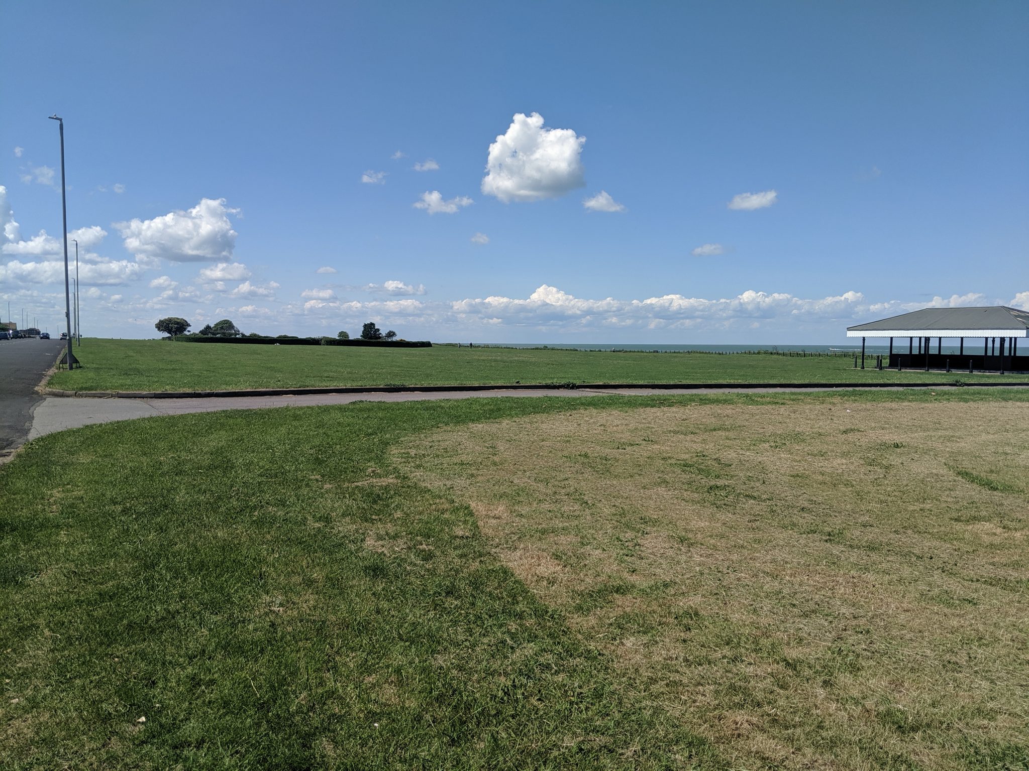 Large green open space with a view of the sea