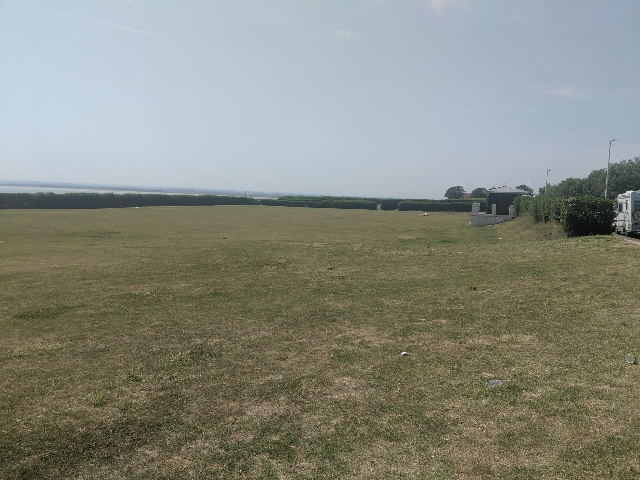 Large green open space with hedges around the outside
