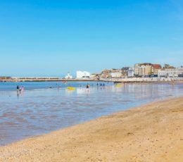 A sandy beach with buildings in the distance