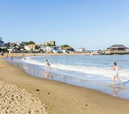 Two people running on the sandy beach