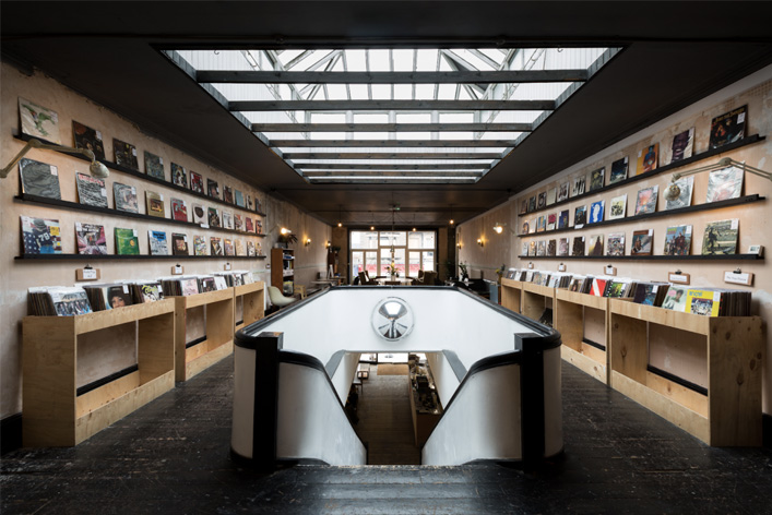 Inside Cliff's shop are rows of shelves with vinyls with stairs leading to a lower level.