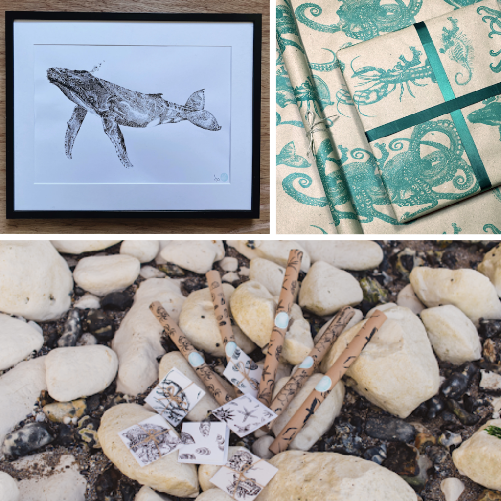 Framed whale artwork with bright blue ocean print wrapping paper. Pebbles along bottom of image with wrapping paper placed in a stylised way.