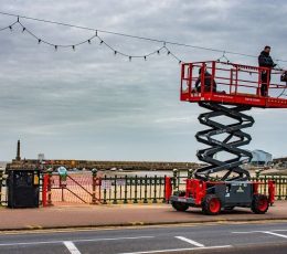 Festoon lights on Margate Seafront being removed by person standing on raised platform