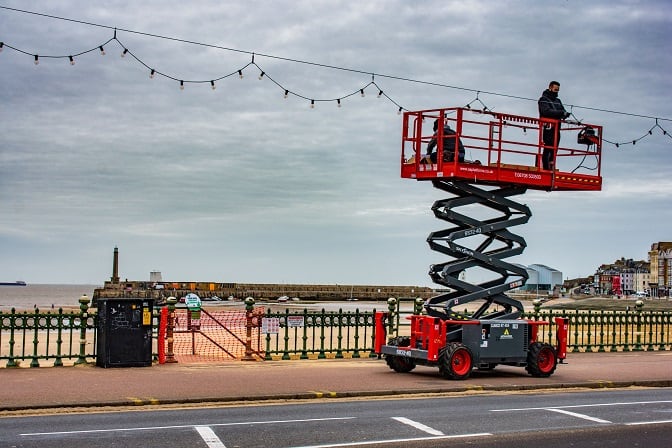 Festoon lights on Margate Seafront being removed by person standing on raised platform