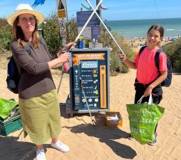 Volunteer adult and child with litter pickers and bag to collect litter