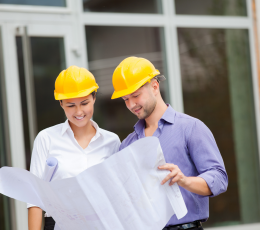 Man and Woman in hard hats looking at plans