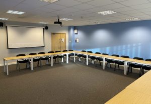 A set of tables and chairs organised in a c shape