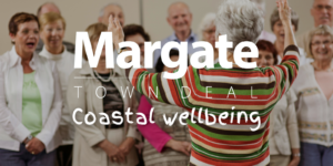 12 older adults singing together with a lady in the foreground conducting the group