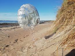 Inflated silver helium balloon hoovering on a coastal location
