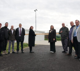 Councillors and council officers standing in front of the new pavilion at Jackey Bakers, about to cut the ribbon.
