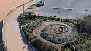 An aerial view of coastal garden with a spiral made of stones.