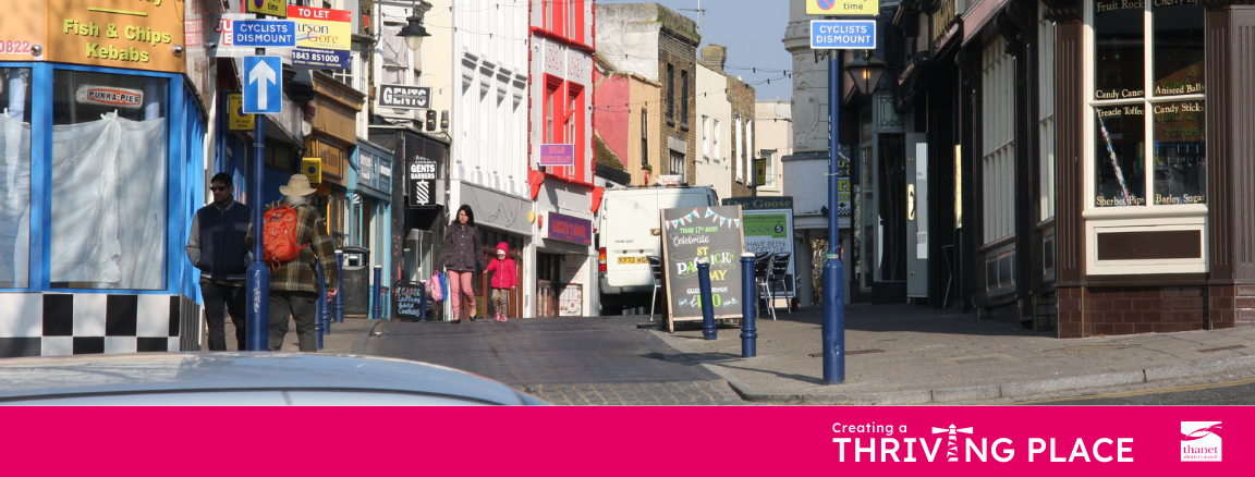 A photograph of a sunny, busy high street with pedestrians walking past shops, including a fish and chip shop and a sweet shop. A bright pink banner at the bottom reads 'Creating a THRIVING PLACE' with a stylized lighthouse graphic replacing the letter 'I', alongside the Thanet District Council logo.