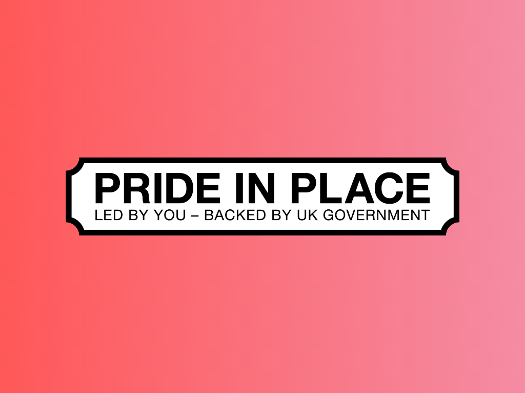 White street sign on a pink background reading: PRIDE IN PLACE. LED BY YOU – BACKED BY UK GOVERNMENT.