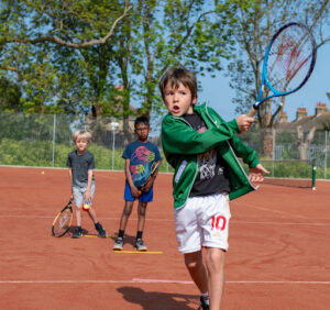 A young boy playing tennis