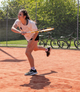 A young girl playing tennis